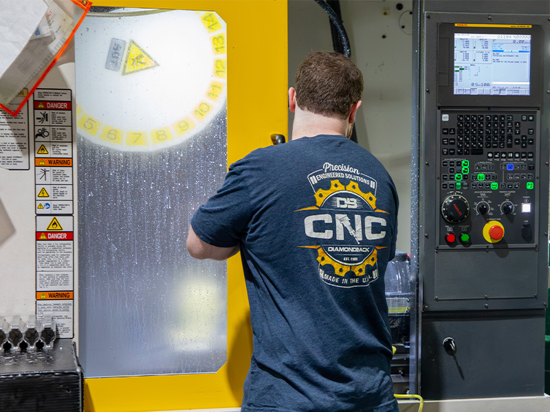 A Diamondback CNC technician working at a machining center