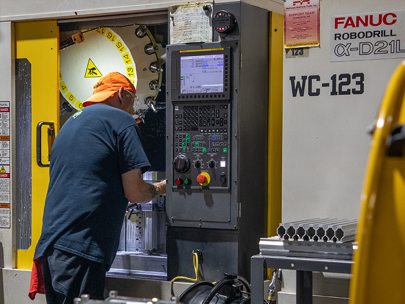 A Diamondback CNC operator working at a FANUC machining center