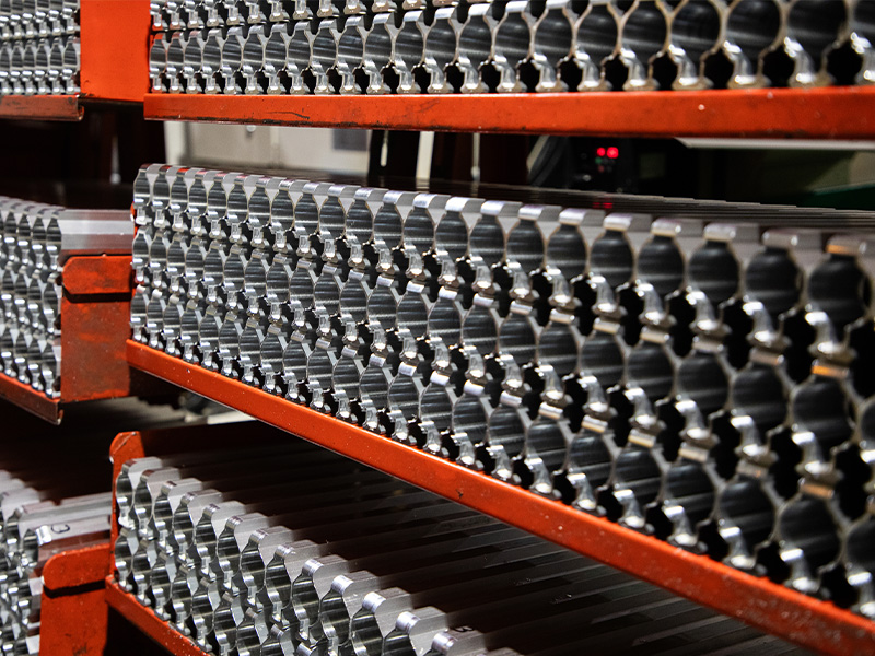 Rows of machined metal parts on production racks