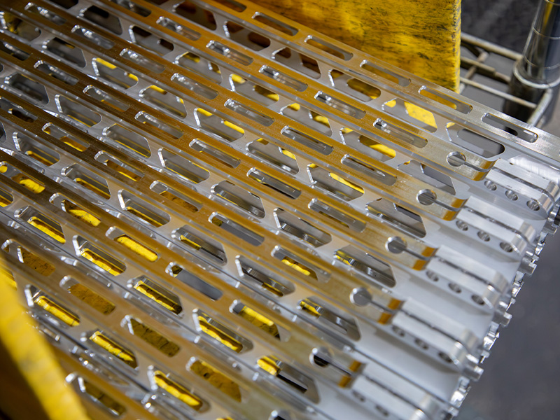 Rows of machined metal components arranged on production racks