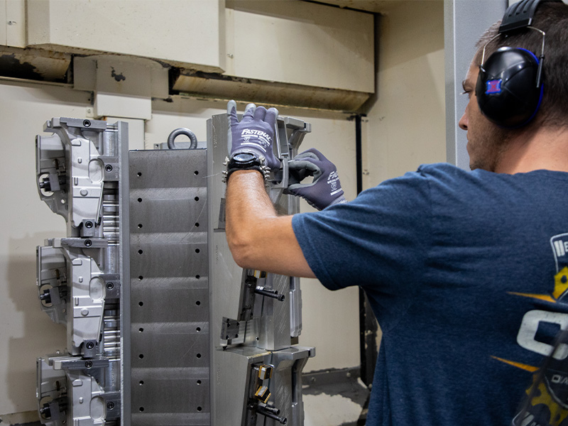 A Diamondback CNC operator setting up a fixture inside a machining center