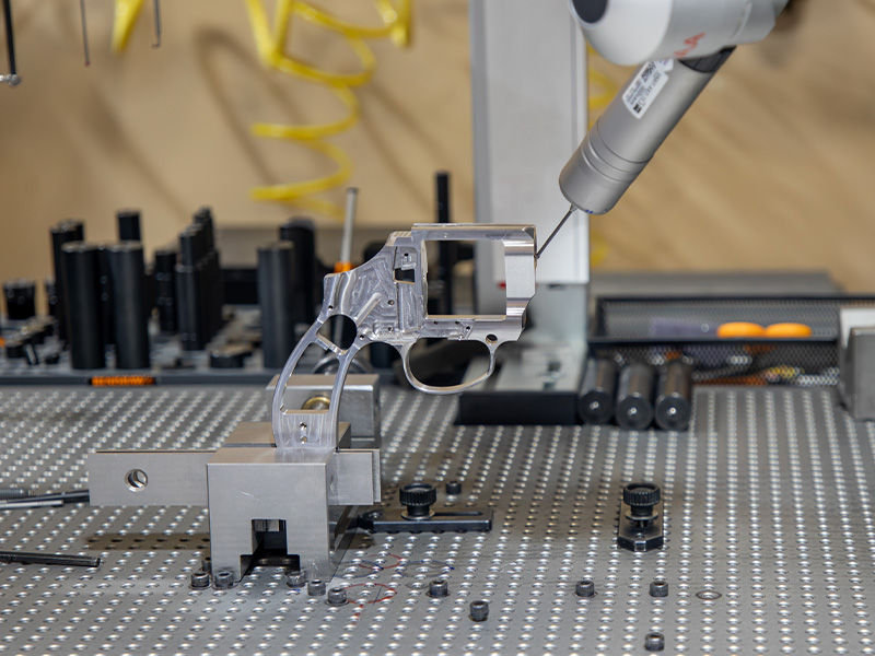 A coordinate measuring machine probing a component on an inspection table
