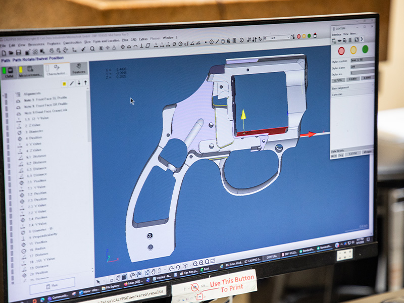 A computer displaying a digital model of a machined component